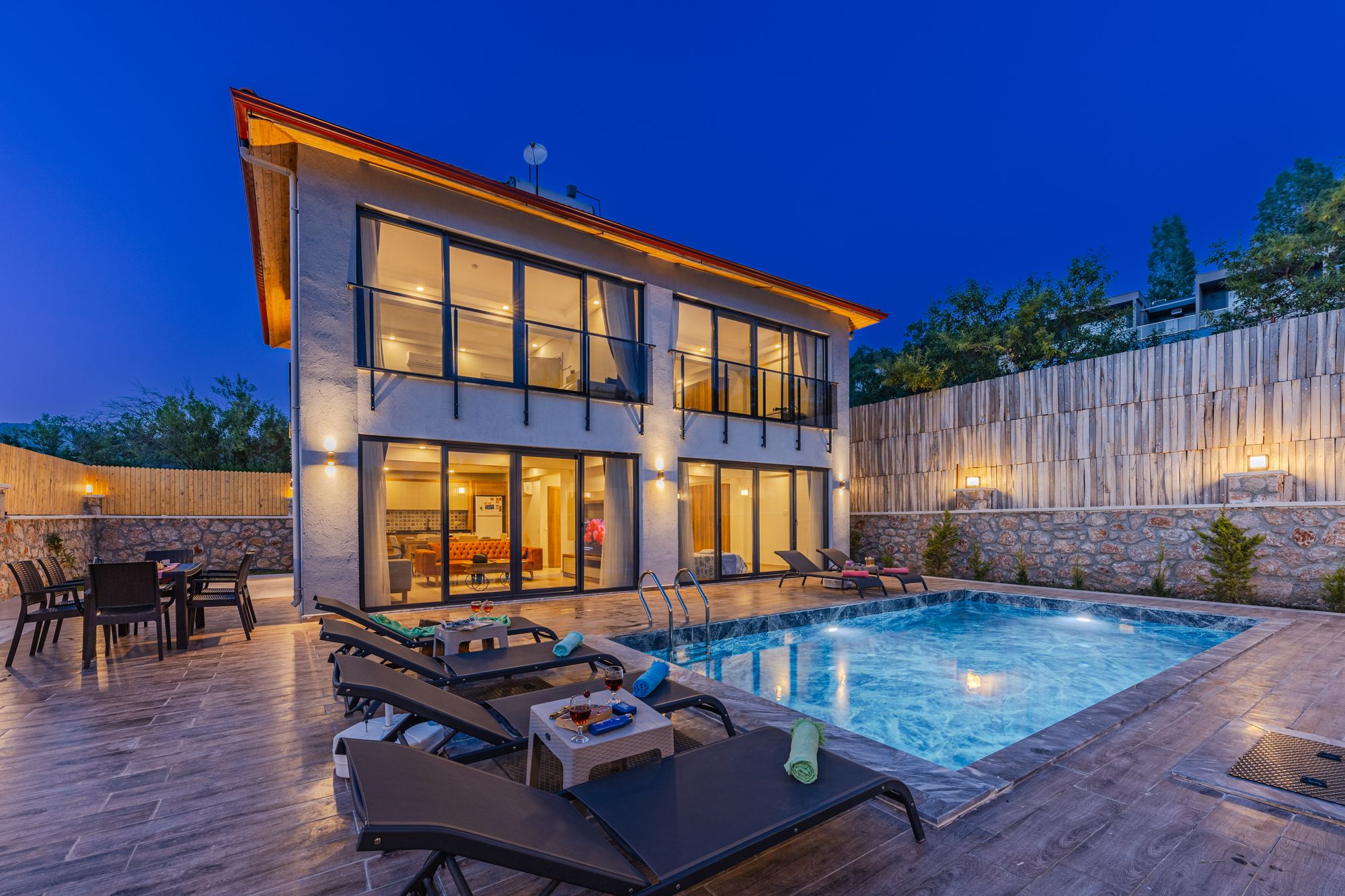 Contemporary residence with an illuminated pool at twilight
